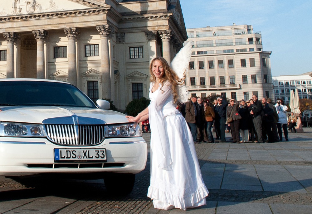 Engel Angela mit Zuschauern vor einer weißen Limousine am Gendarmenmarkt